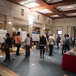 The Graduate Showcase, with many student posters, a buffet table, and people movng around the room